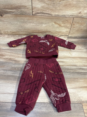 Top down view of maroon Harry Potter two piece sweatshirt and pants set with an all over wizard themed print on wood flooring