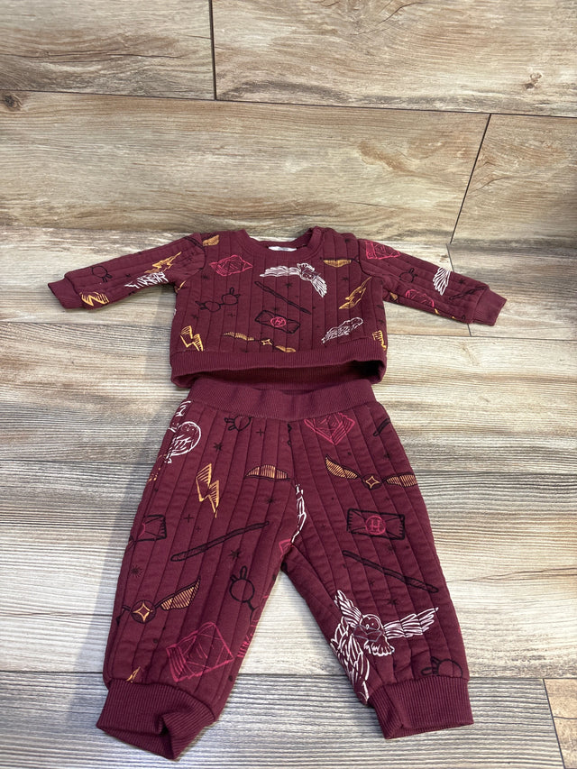 Top down view of maroon Harry Potter two piece sweatshirt and pants set with an all over wizard themed print on wood flooring