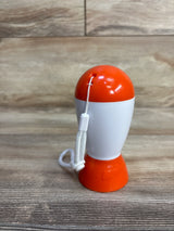 Front view of Baby Shusher sleep soother showing orange-and-white casing and wrist strap on wood tabletop
