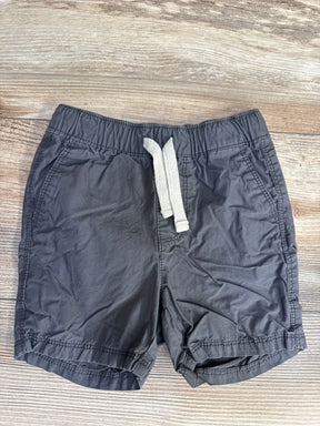Flat lay of grey Old Navy toddler drawstring shorts showing elastic waistband with white drawstring and side pockets on light wood background