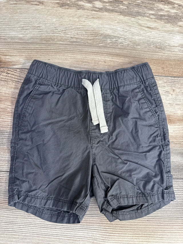 Flat lay of grey Old Navy toddler drawstring shorts showing elastic waistband with white drawstring and side pockets on light wood background