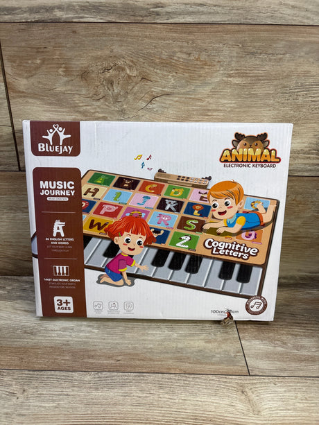 Front view of BlueJay animal electronic piano mat box showing keyboard with colorful alphabet tiles on wood floor