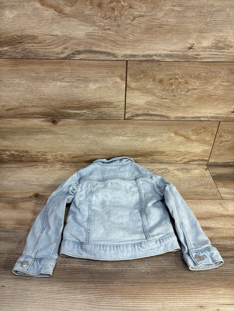Back view of Cat & Jack light-wash denim toddler jacket, size 4T, showing back seam and button cuffs laid flat on wood floor