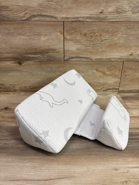 Angled view of Klynic Baby Wedge Support Pillow showcasing its white textured cover and wedge shape on a wood surface