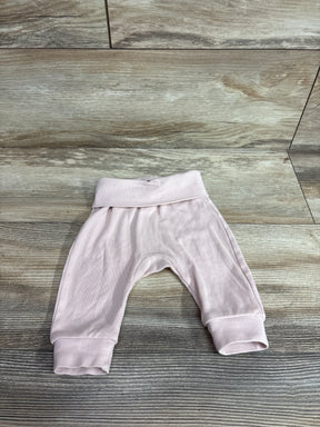 Flat lay of pink H&M foldover-waist baby pants showing fold-over waistband and cuffed legs on wood background
