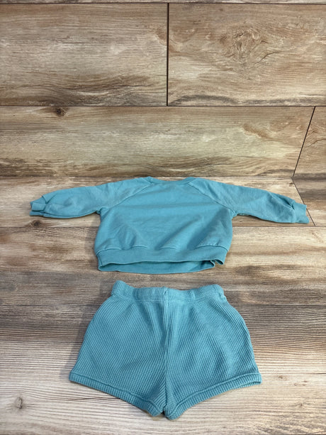Flat lay of teal long-sleeve top and waffle-knit shorts for 3-6M showcasing textured waffle knit and elastic waistband on wood background