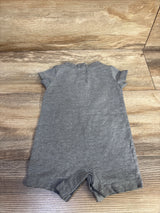 Flat lay of grey Nike shortie romper size 3M showing short sleeves and back snap placket on wood background