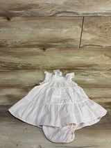 Pink striped baby dress with ruffled sleeves and tiered skirt on wooden floor