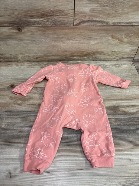 Top view of a pink Huggies baby sleeper in size 9m showcasing a white floral pattern with a wood-grain background