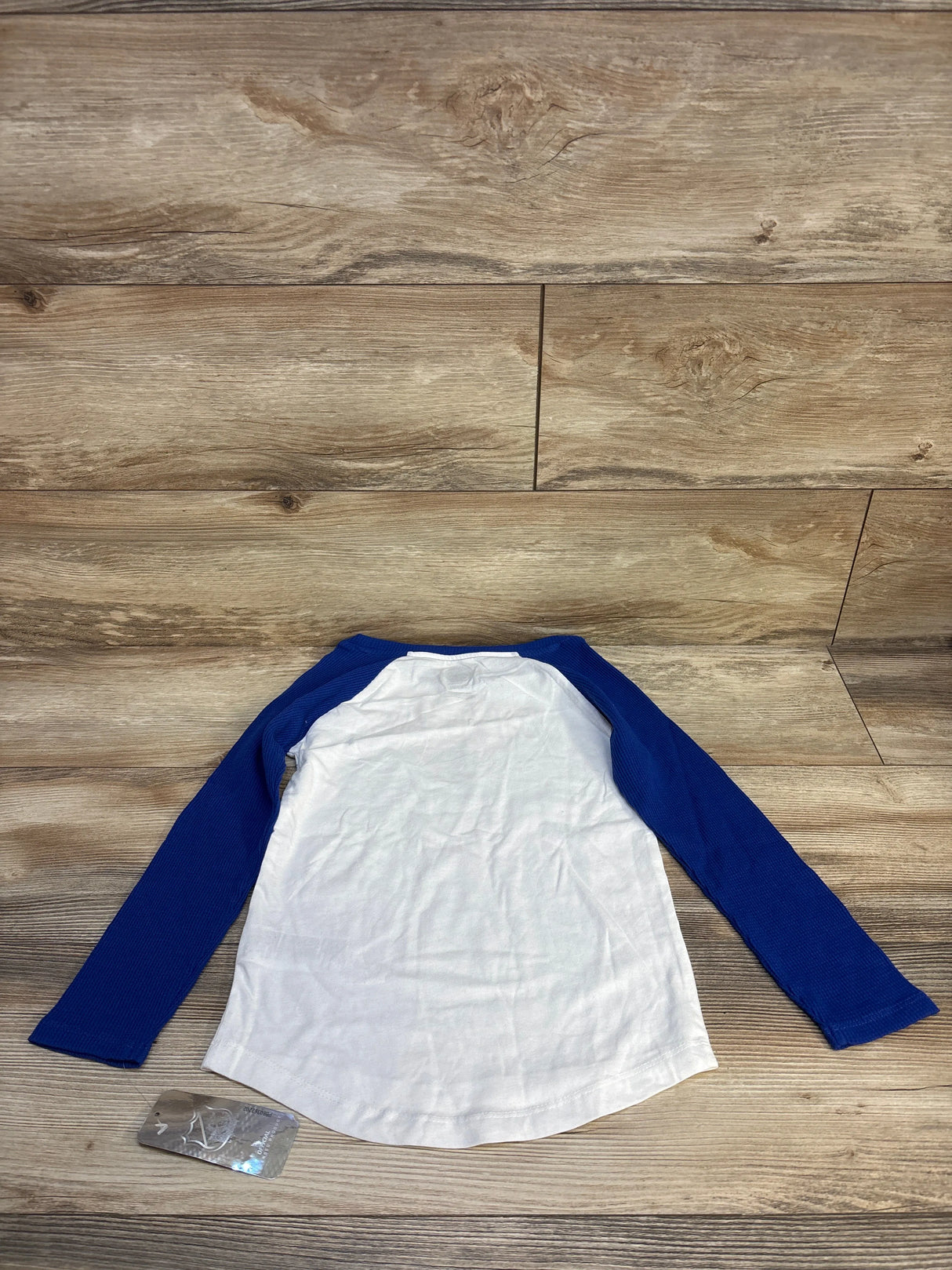 Kids white and blue long sleeve raglan shirt on wood background