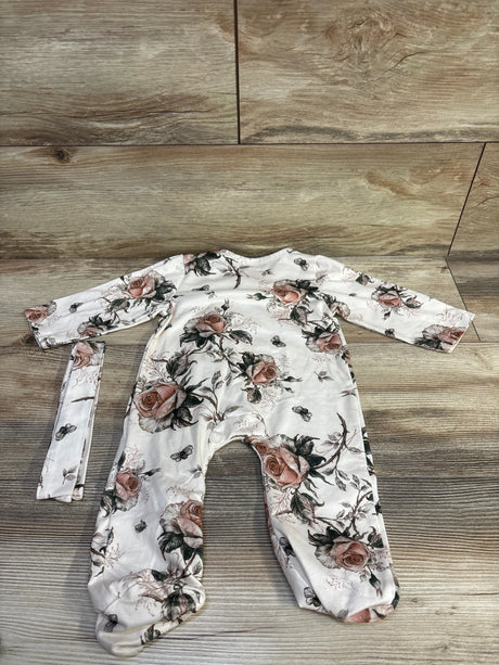 Flat lay of 3-6M beige floral snap ruffle sleeper with matching headband showing rose print on wood floor