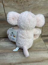 Back view of Cloud Island pink elephant plush showing soft fuzzy fur, small tail, and retail tags on a wood floor background