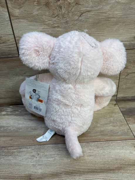 Back view of Cloud Island pink elephant plush showing soft fuzzy fur, small tail, and retail tags on a wood floor background