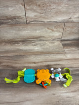 Top view of Bright Starts take along carrier toy bar showcasing teal teether orange tiger rattle and zebra clip toy with green straps on wood plank floor