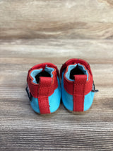 Red and blue baby moccasins with soft sole, ideal for infants and toddlers, displayed on wood floor.