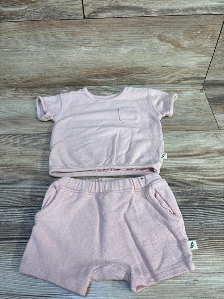 Flat lay of pink Easy Peasy short-sleeve shirt and elastic-waist shorts showing terry texture, chest pocket, and side tags