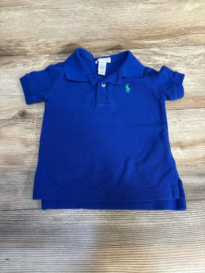 Blue toddler polo shirt with green embroidered logo on wooden surface