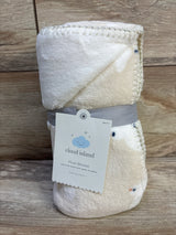 Rolled view of Cloud Island plush blanket in off white showing terry texture, stitched edge and gray tag on wood background