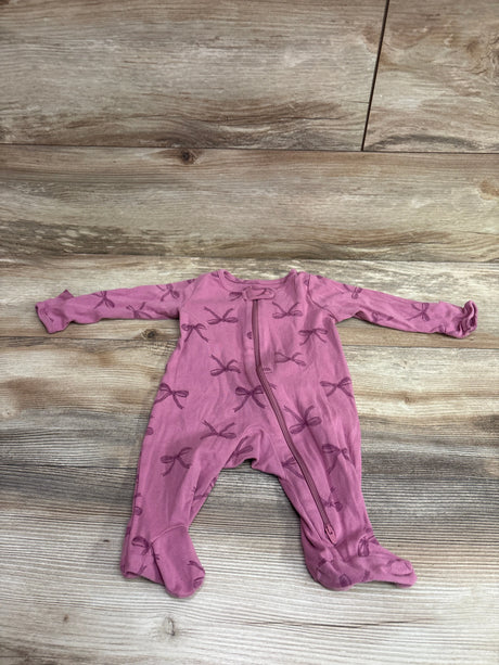 Top view of Just One You pink sleeper, size 3 months, with bow pattern, footed legs, and front zipper on wood background