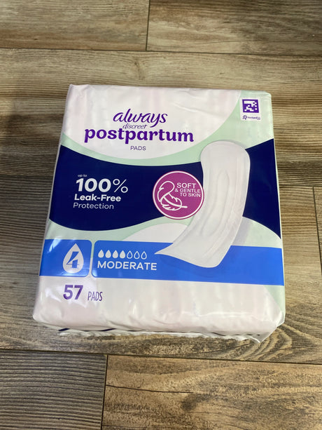 Front view of Always Discreet postpartum pads, moderate absorbency, 57 count, 100 percent leak-free on wood floor