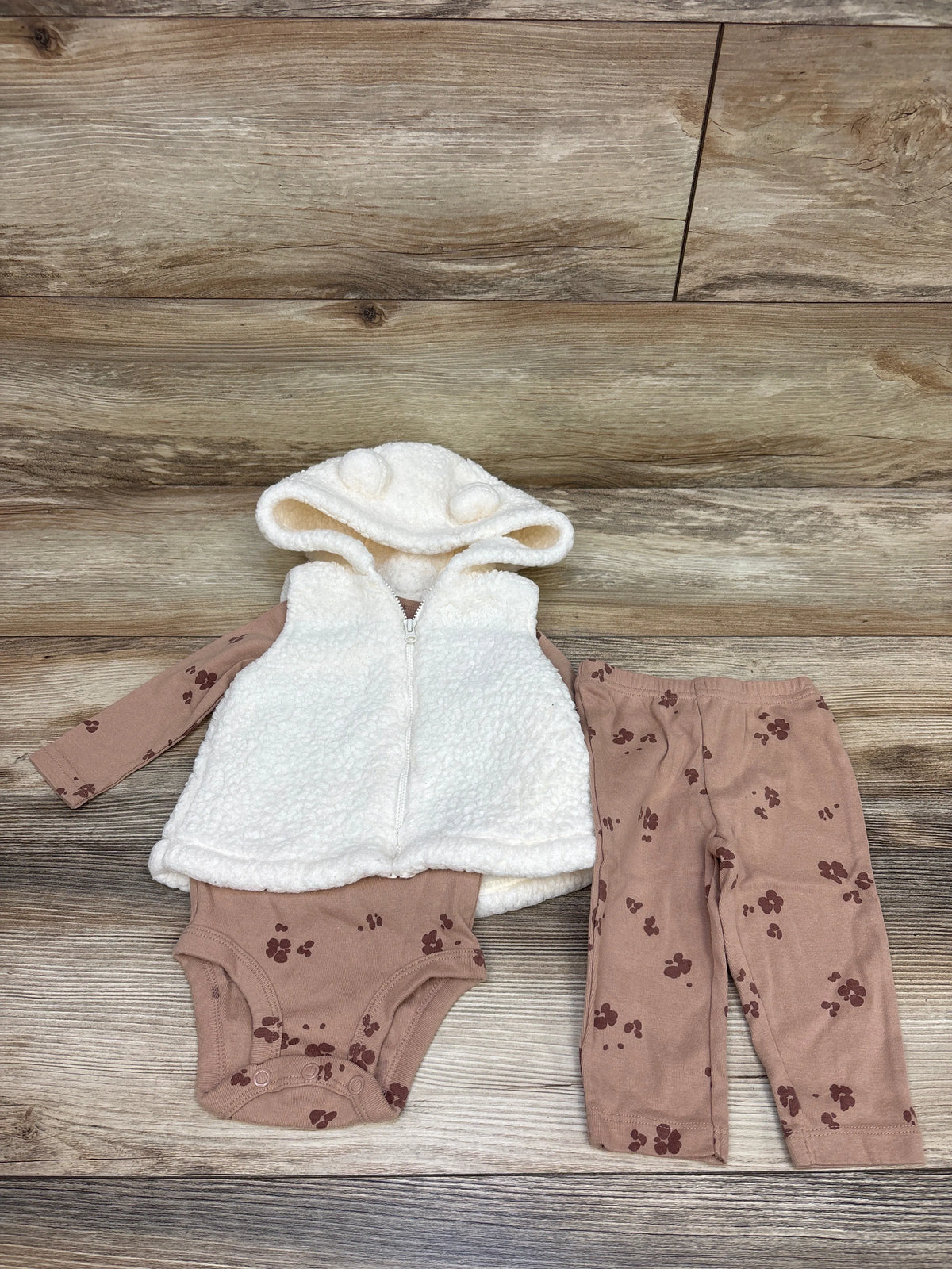Front view of Child Of Mine three-piece sherpa hooded vest, floral bodysuit, and pants set with white vest and brown pieces
