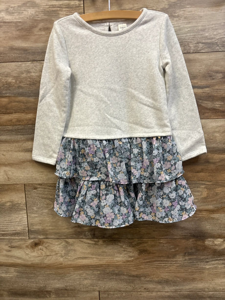 Front view of Oshkosh sweatshirt dress in gray, size 5T, showcasing a floral two-tier ruffled skirt on a wood floor