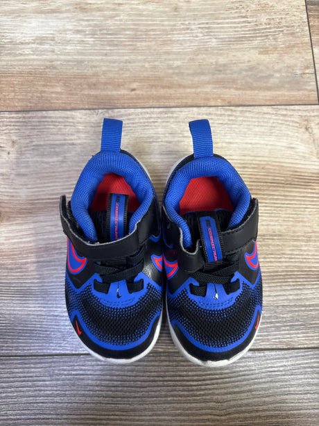 Top view of Nike Cosmic Runner TD sneakers showcasing black and Hyper Royal color blocking, red accents, and hook and loop straps on a wood floor