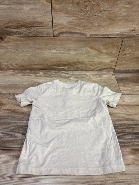Back view of an ivory Oshkosh henley shirt in size 4T showcasing short sleeves with a wood plank background