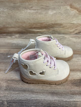 Ivory toddler boots with pink laces and heart cutouts, kids shoes on wood background