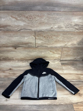 Kids Nike zip-up hoodie, black and gray, laid flat on wood floor
