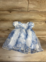 White and blue floral baby dress with puff sleeves on wood background
