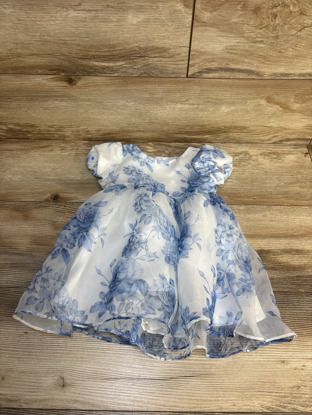 White and blue floral baby dress with puff sleeves on wood background