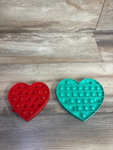 Red and teal heart-shaped pop-it fidget toys on a wood-textured surface, kids sensory toy