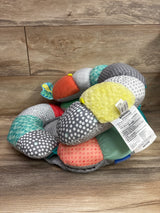 Angled view of Infantino 2-in-1 Tummy Time & Seated Support showcasing multicolored patterned cushions on a wood floor