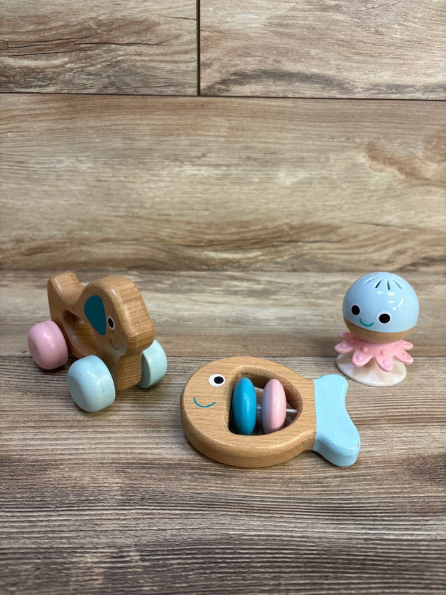 Wooden toy car, fish rattle, and octopus figure on wooden surface, baby toys resale