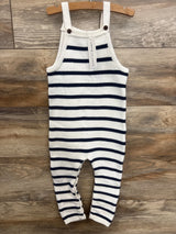 Front view of Janie & Jack striped knit overalls in white and navy, showing wooden button shoulder straps on wood plank background