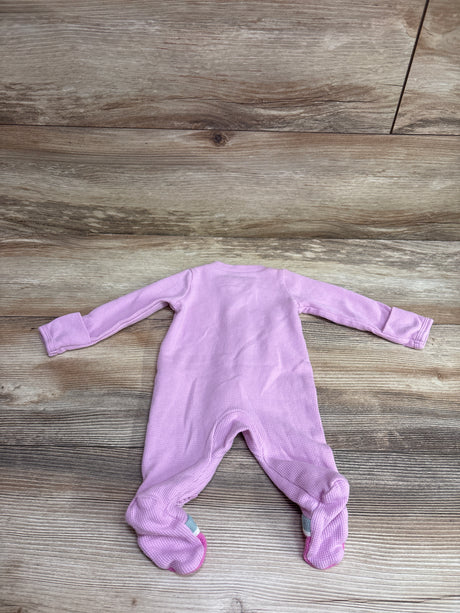 Front view of a pink Just One You waffle-knit footed sleeper in newborn size with long sleeves on a wood-look floor