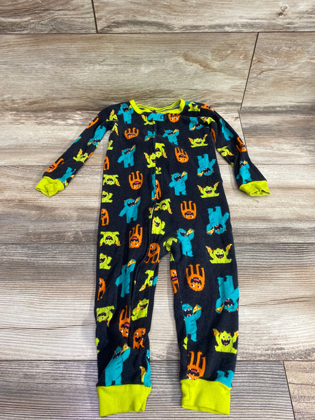 Front view of Simple Joys black sleeper with colorful monster print and lime green trim on a wood floor
