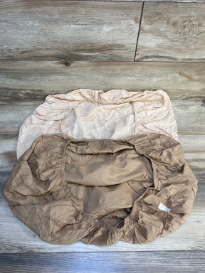Two neutral fitted crib sheets with elastic edges on wood floor, baby bedding essentials
