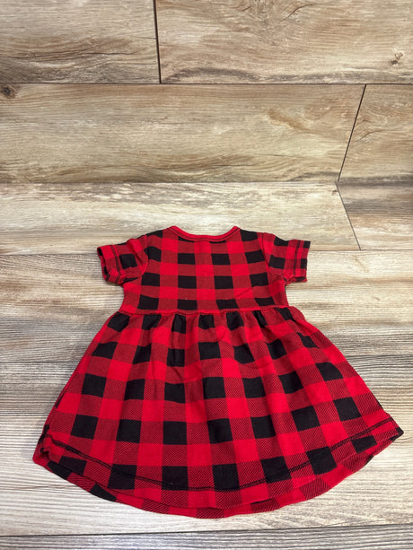 Front view of Touched By Nature red buffalo plaid dress in size 9 to 12 months, with short sleeves, on a wood floor