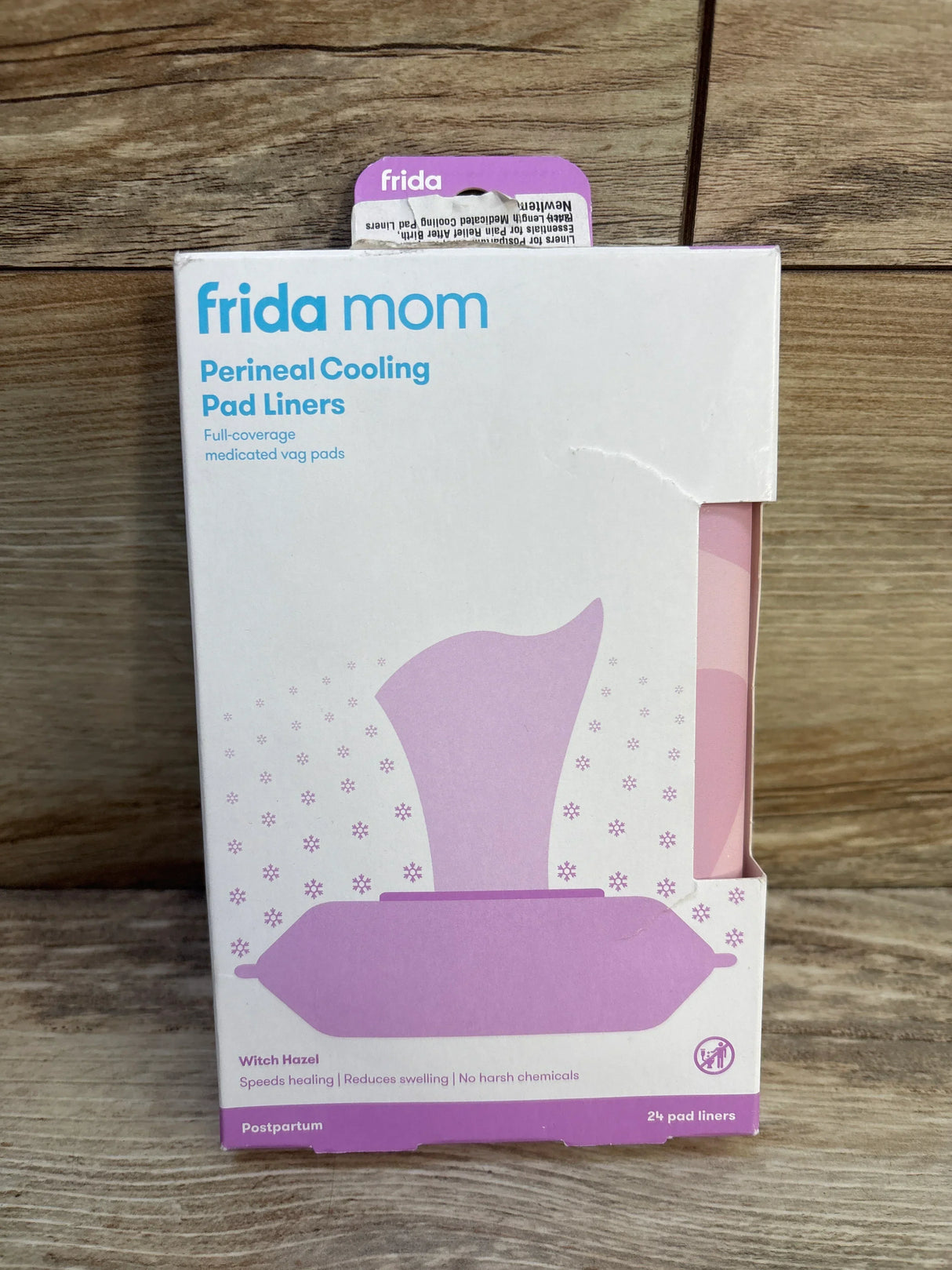 Front view of Frida Mom Perineal Cooling Pad Liners box showing Witch Hazel pads, 24 count, on wood background