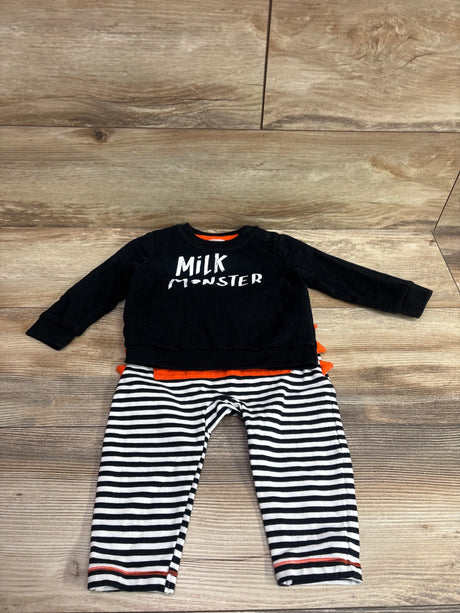 Flat lay of Cat and Jack 2pc Milk Monster sweatshirt and joggers set showcasing a black top, striped pants, and orange accents
