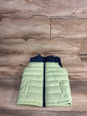 Light green and navy toddler puffer vest with zipper on wood background