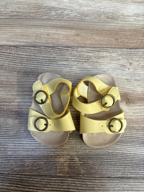Yellow toddler sandals with buckles on wooden background, kids footwear resale