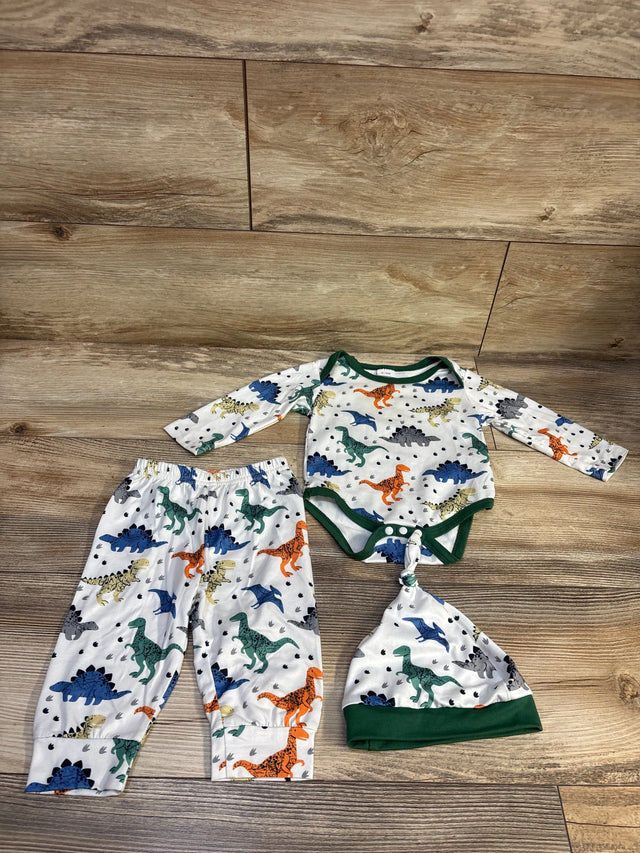 Top view of three-piece dinosaur bodysuit, pants, and hat set showcasing colorful dinosaur print and green trim on wood flooring