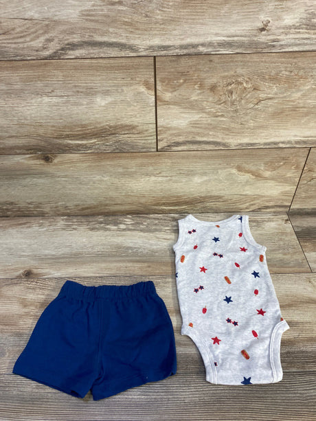 Flat lay of grey sleeveless baby bodysuit with red and blue star print and navy elastic-waist shorts on light wood floor