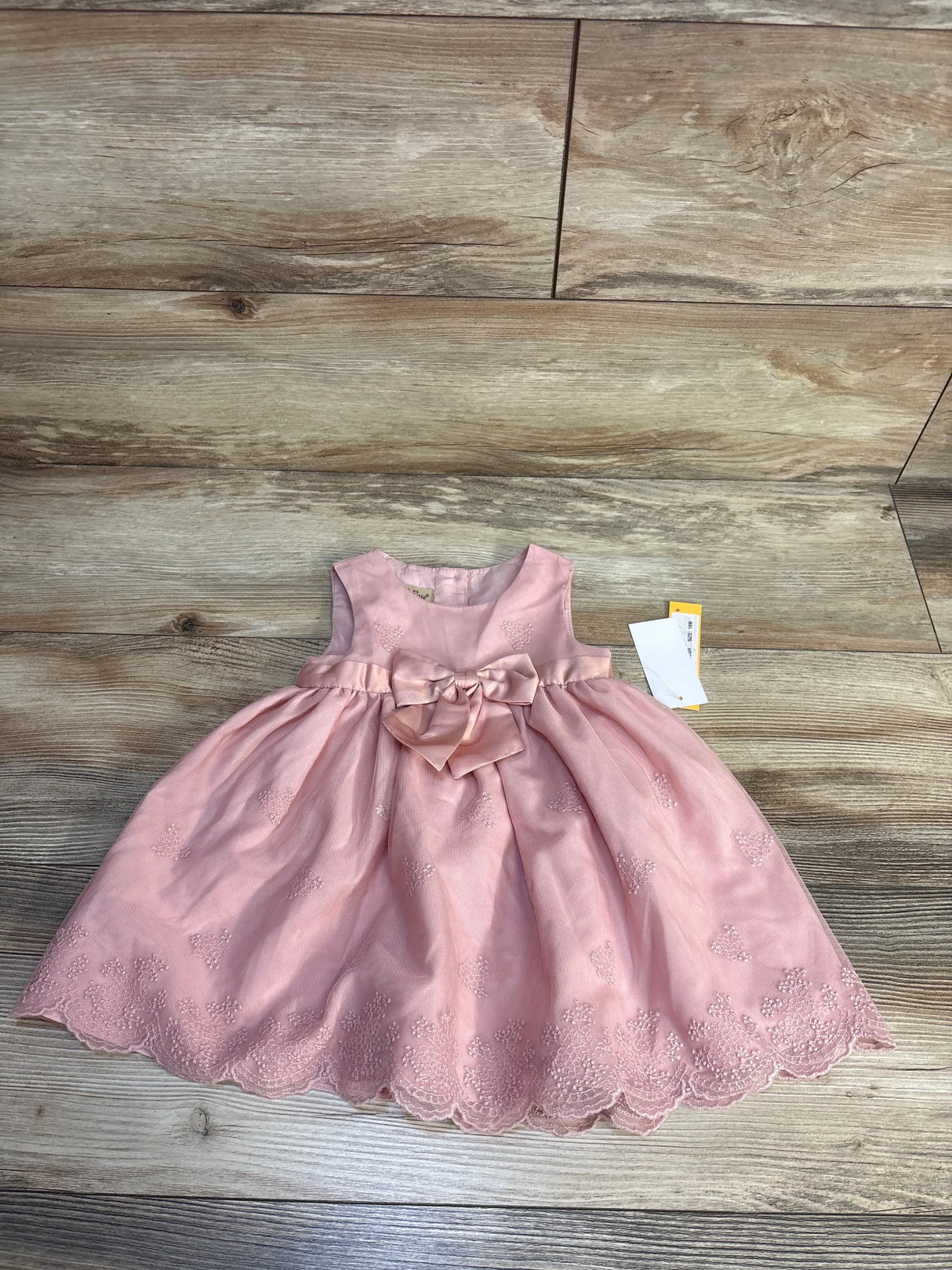 Pink baby dress with bow and lace trim, size 18M, on wood floor