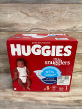 Front view of Huggies Little Snugglers size 1 box showing baby photo and blowout and leak protection callout on wood background