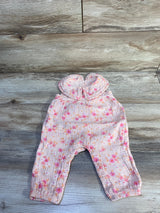 Flat lay of Cat & Jack pink collared gauze baby jumpsuit showing floral print and snap closures on light wood background