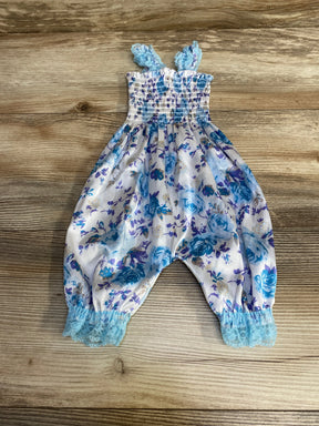 Front view of 3M floral smocked baby romper showcasing smocked bodice, blue and purple floral print and lace-trimmed ankles on wood background